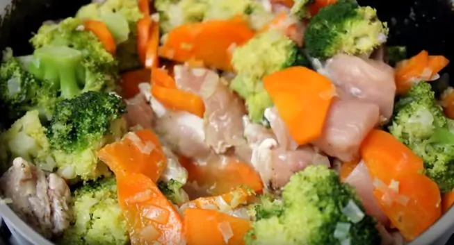 Жареная брокколи на сковороде с овощами и курицей